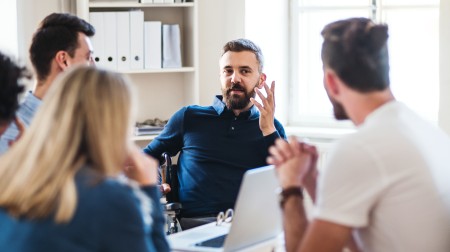 Personer diskuterer rundt et bord